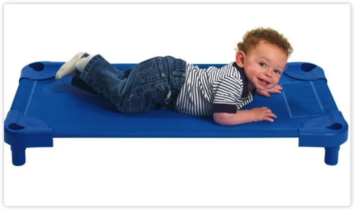 Child lying on a blue low-frame classroom nap cot.